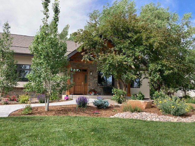 Established front yard landscape with mature trees by Brooks Landscape