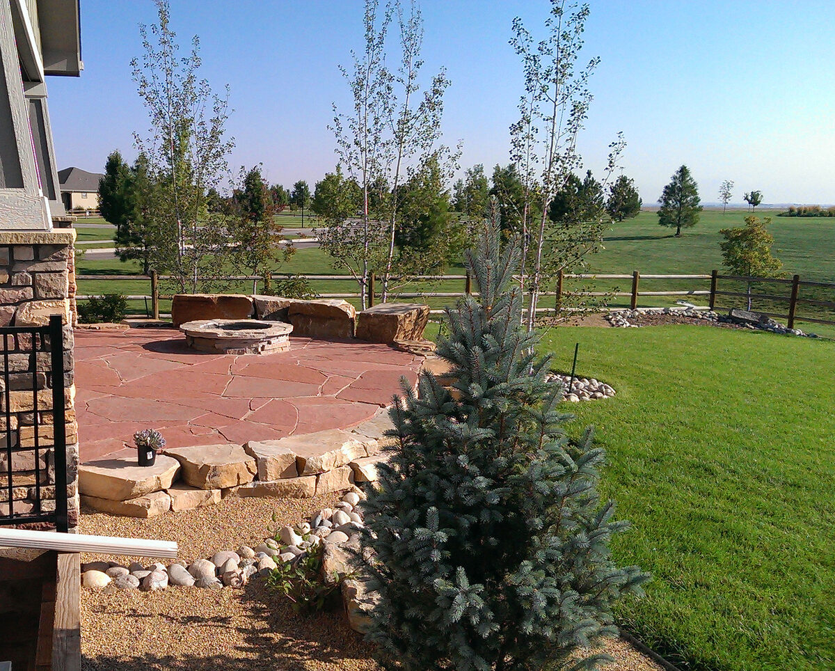 Flagstone patio with a stone fire pit built by Brooks Landscape in Northern Colorado