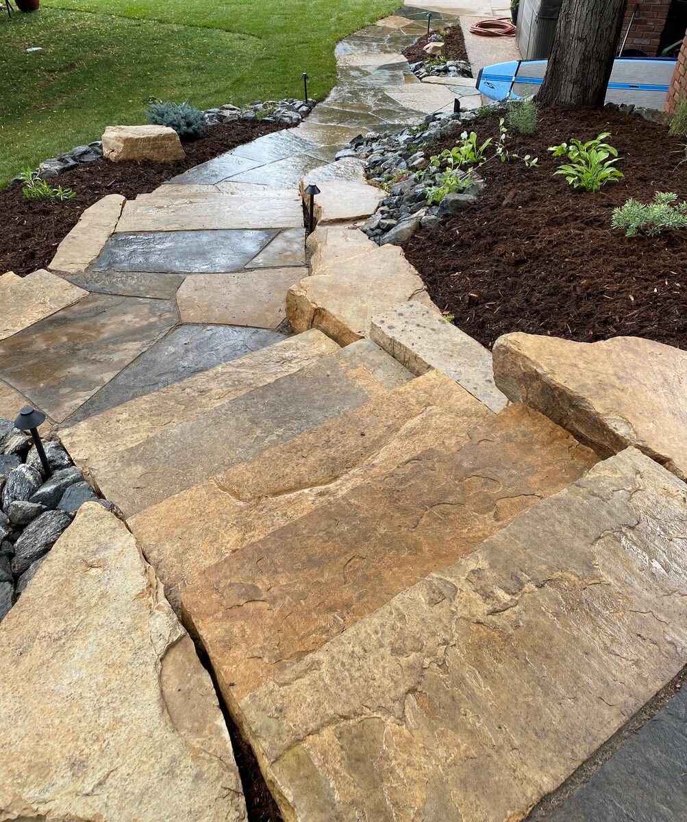 Flagstone path with oversized stone-slab steps by Brooks Landscape