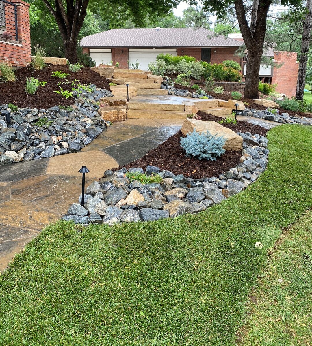 Flagstone walkway with boulder beds by Brooks Landscape