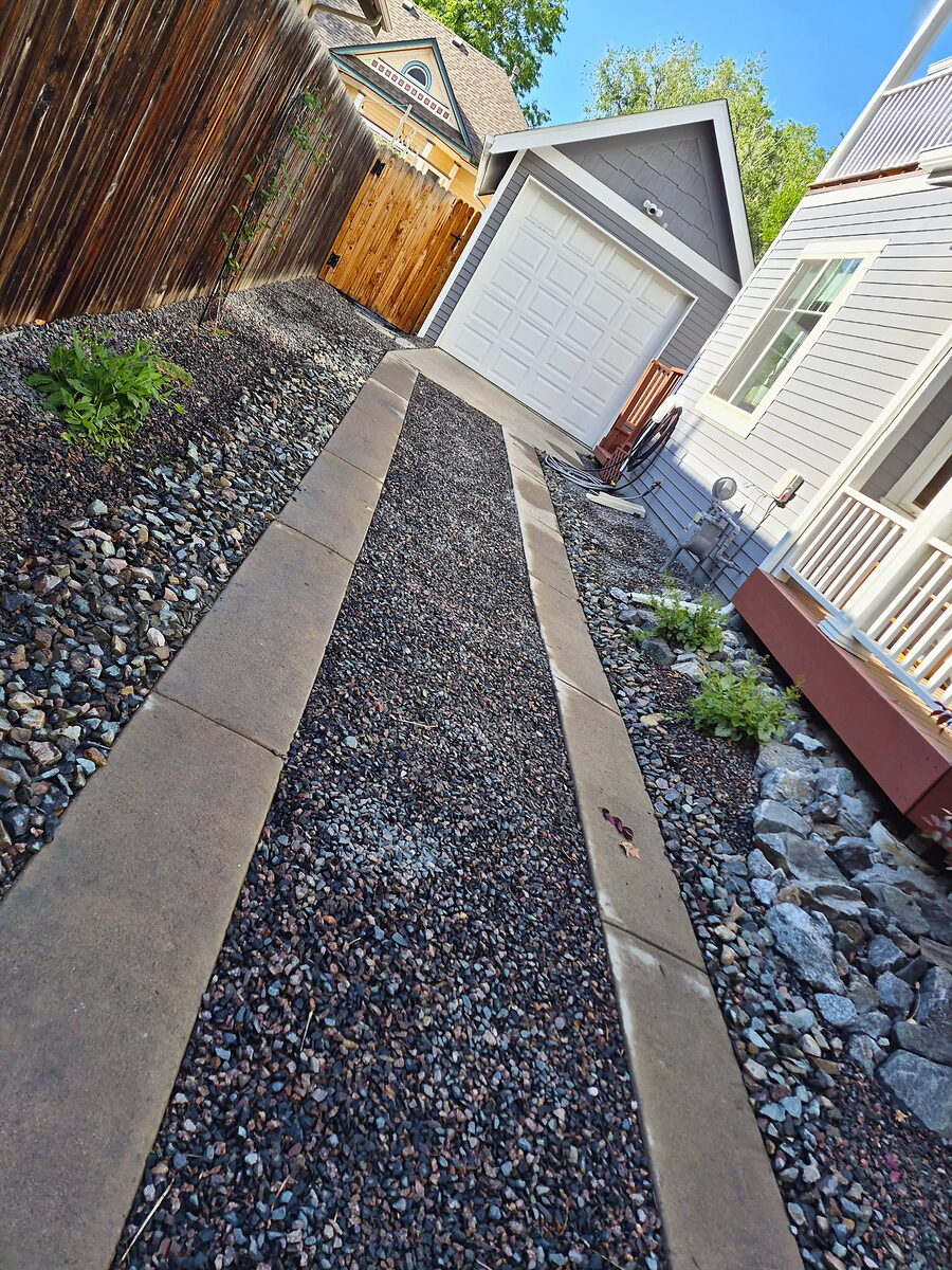 Low-maintenance gravel side yard with a walkway by Brooks Landscape