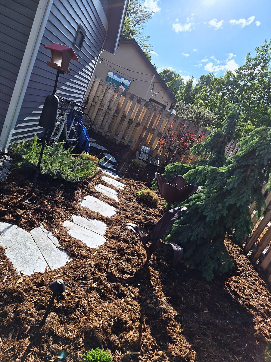 Side yard mulch bed with flagstone stepping stones by Brooks Landscape
