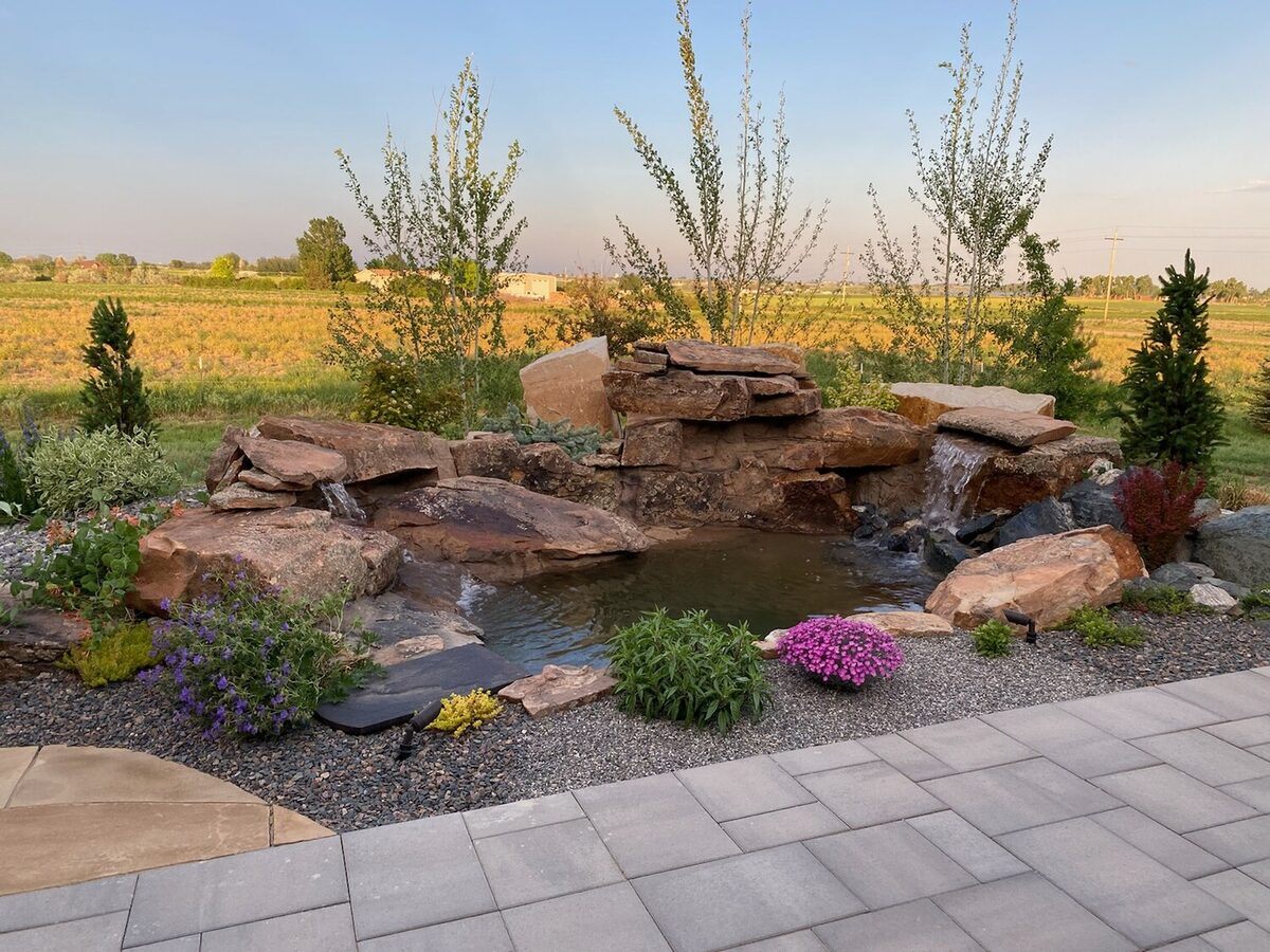 Backyard pond with a boulder waterfall built by Brooks Landscape